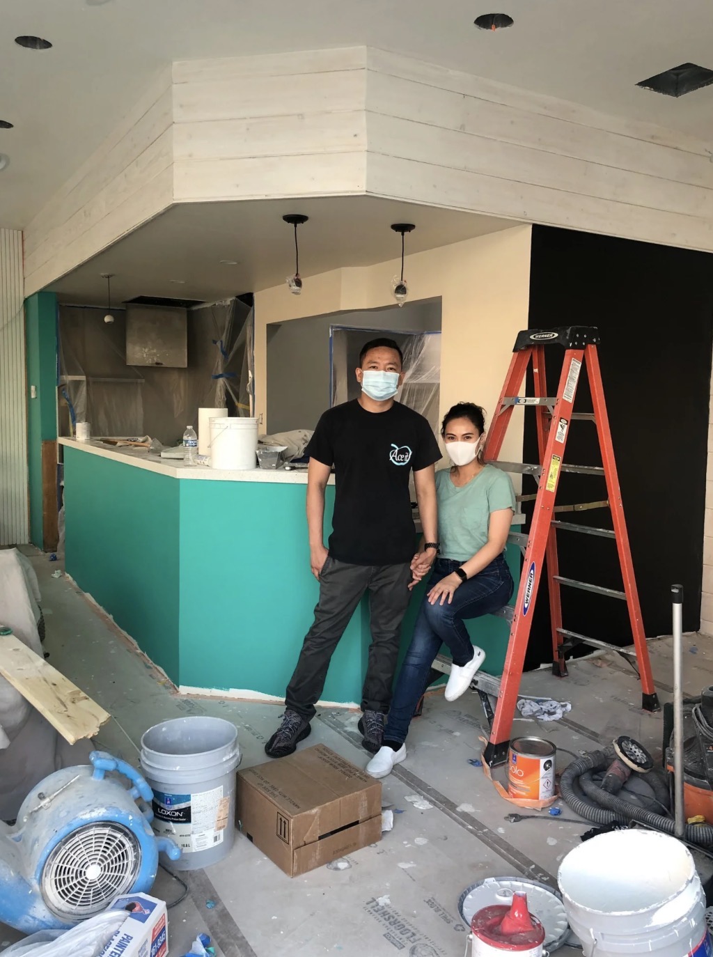 The owners during the original build-out of The Boba Café with paint buckets and a ladder