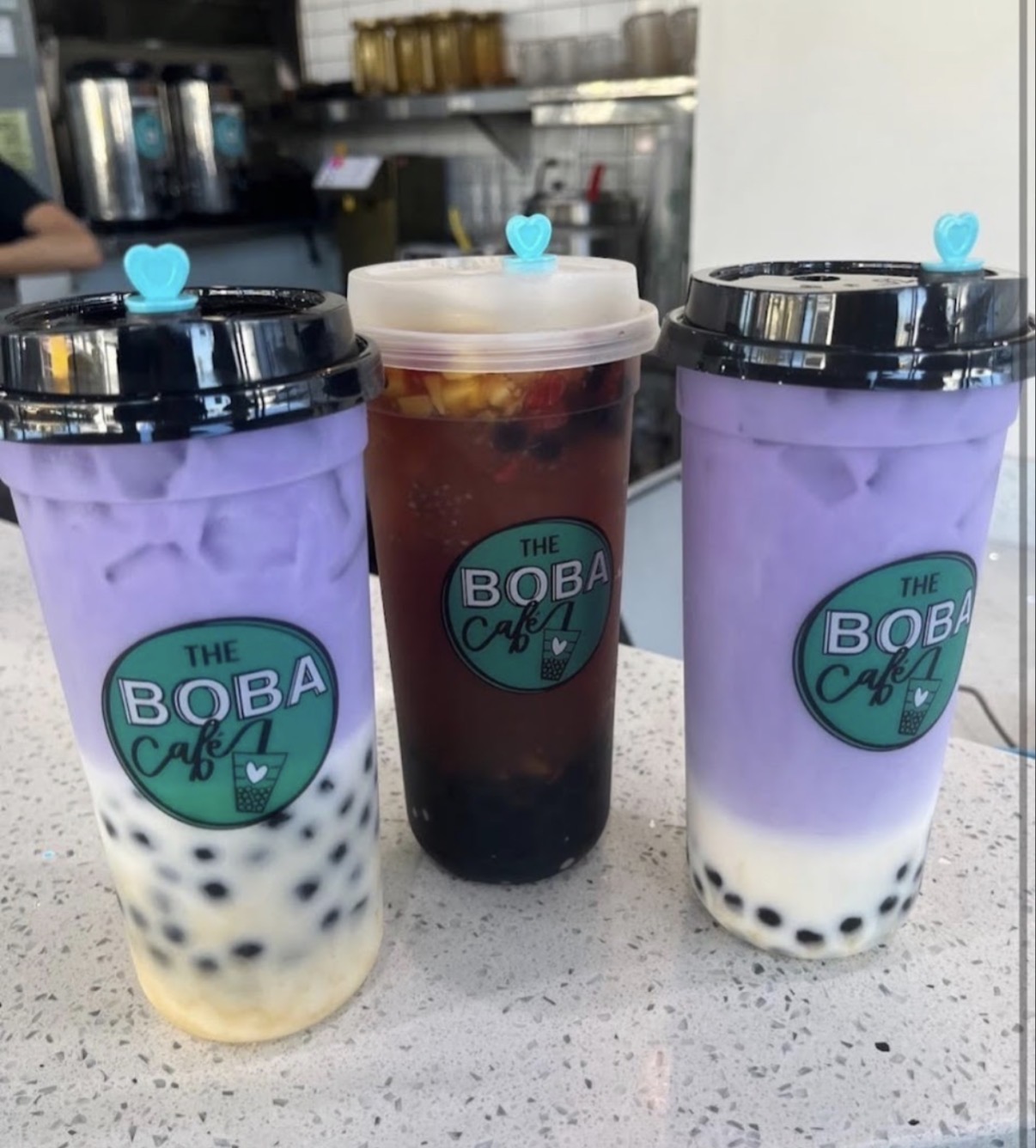 Taro milk tea and fresh fruit tea with the Boba Café logo